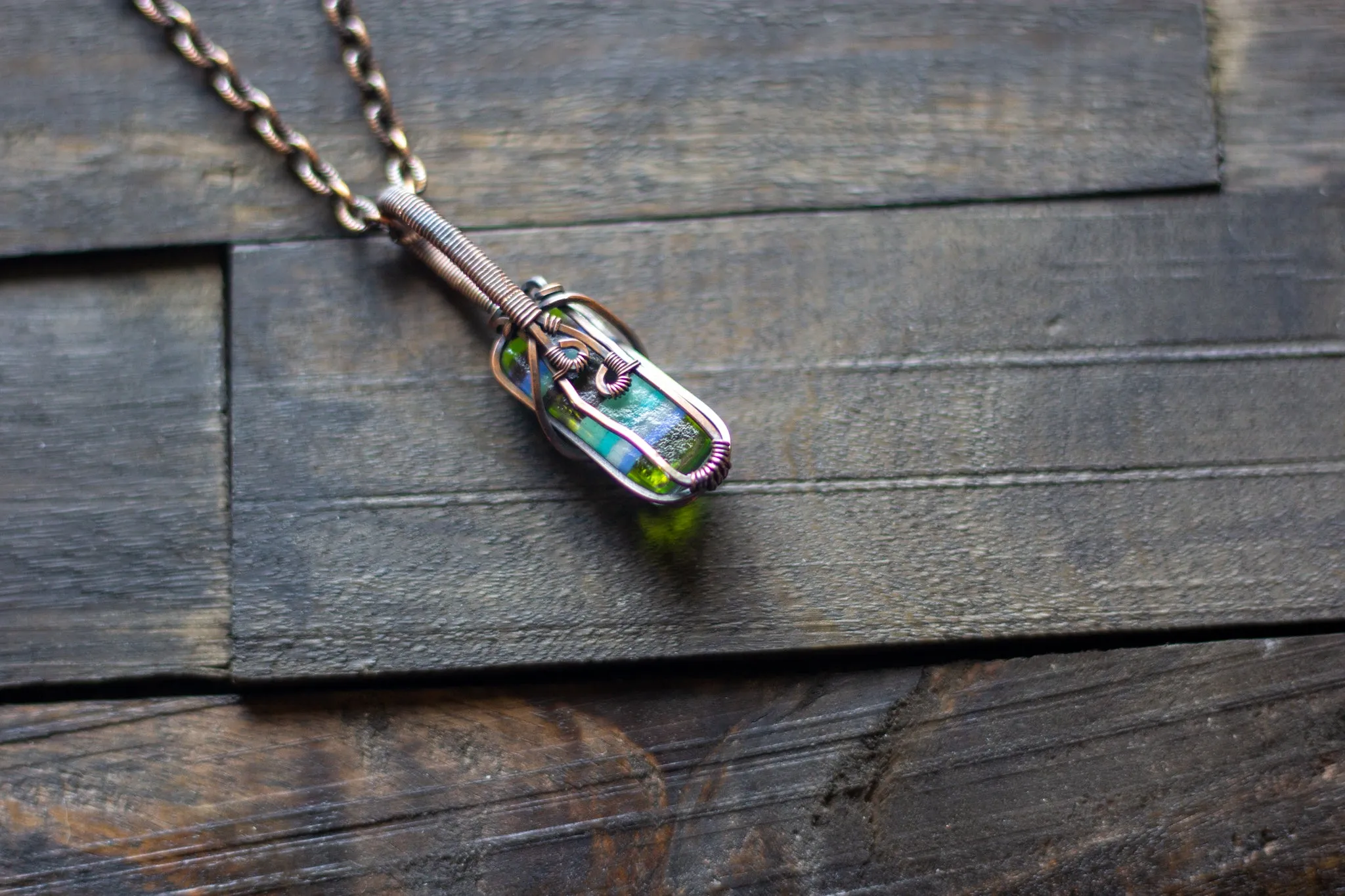 Streaked Green and Blue Fused Glass and Copper Wire Crisscross Pendant
